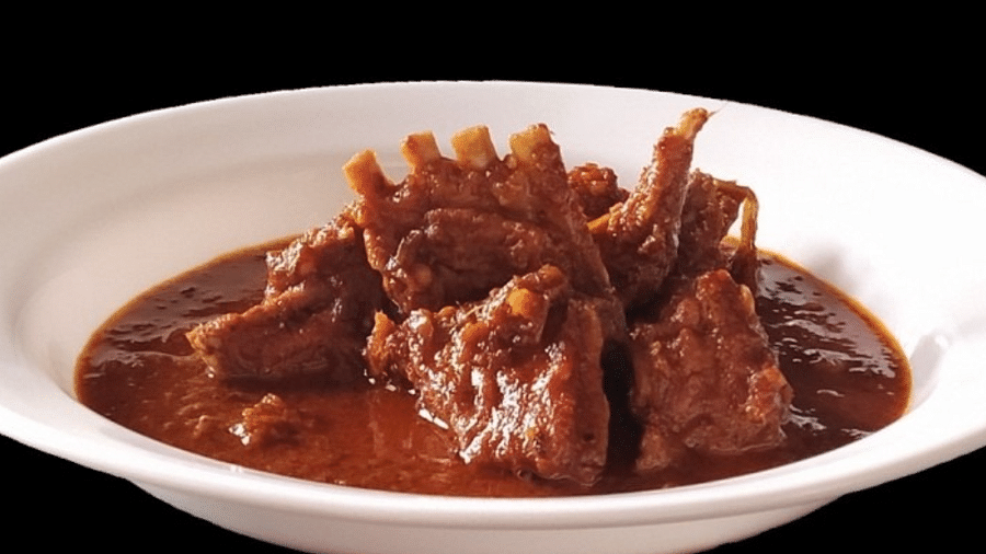 Plate of Mathania Maans featuring tender meat in rich gravy, garnished for an appetizing presentation.