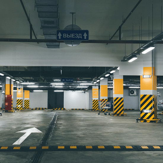an empty underground parking lot in a building with coloured pictures