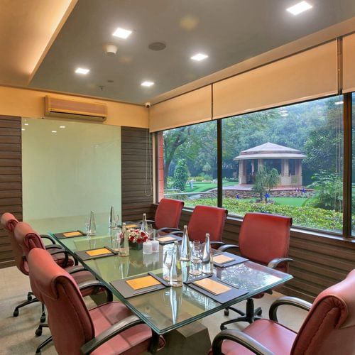 A board room with neatly arranged chairs and glass table at Heritage Village Resorts & Spa.