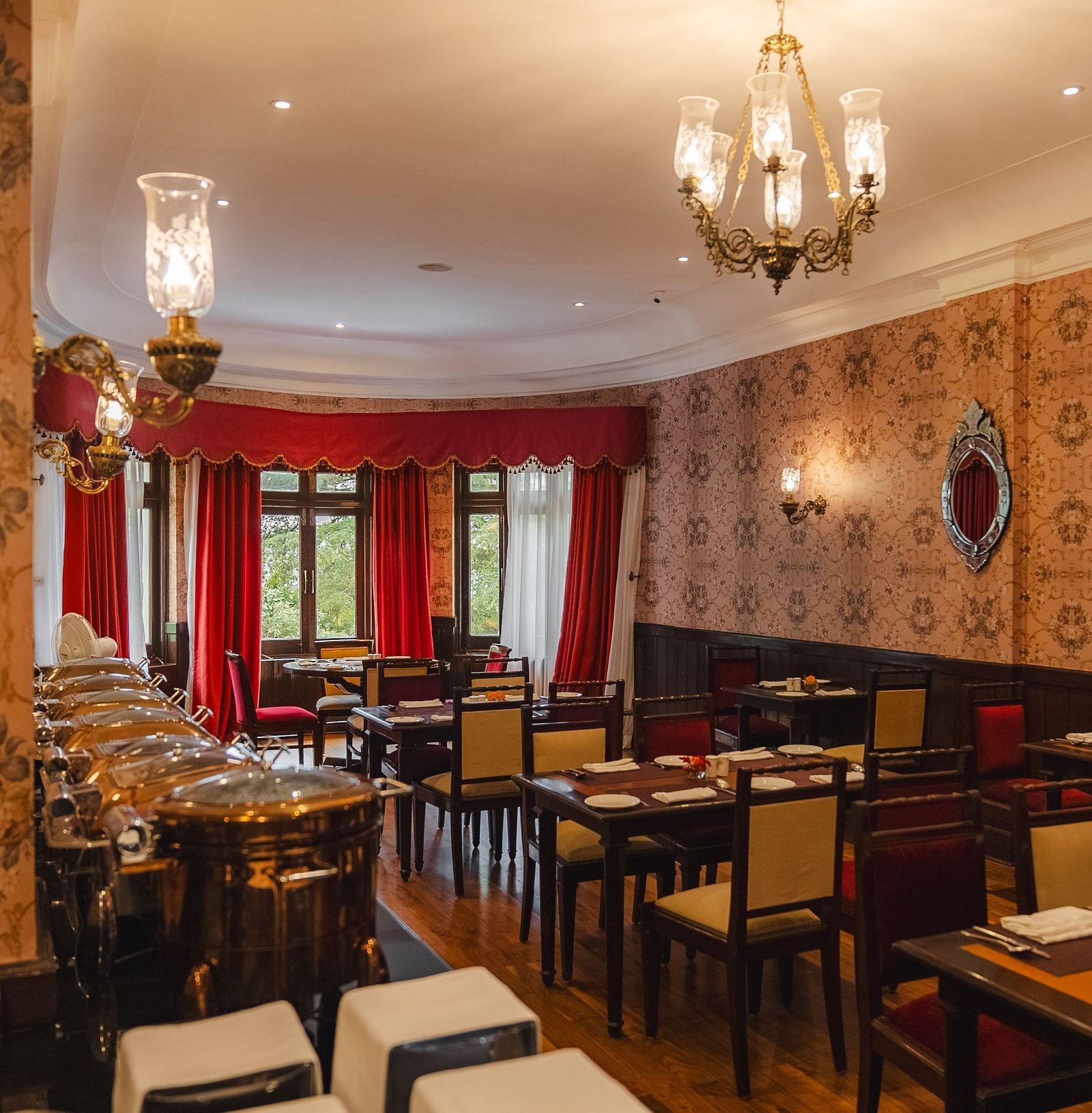 Elegant restaurant with arranged seating and a side buffet at The Claridges Nabha Residence