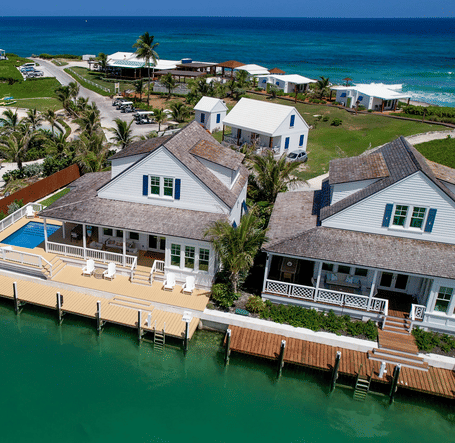 An aerial view of waterfront buildings with private docks, walkways, and surrounding ocean at Shoal Villa in Abaco Inn.