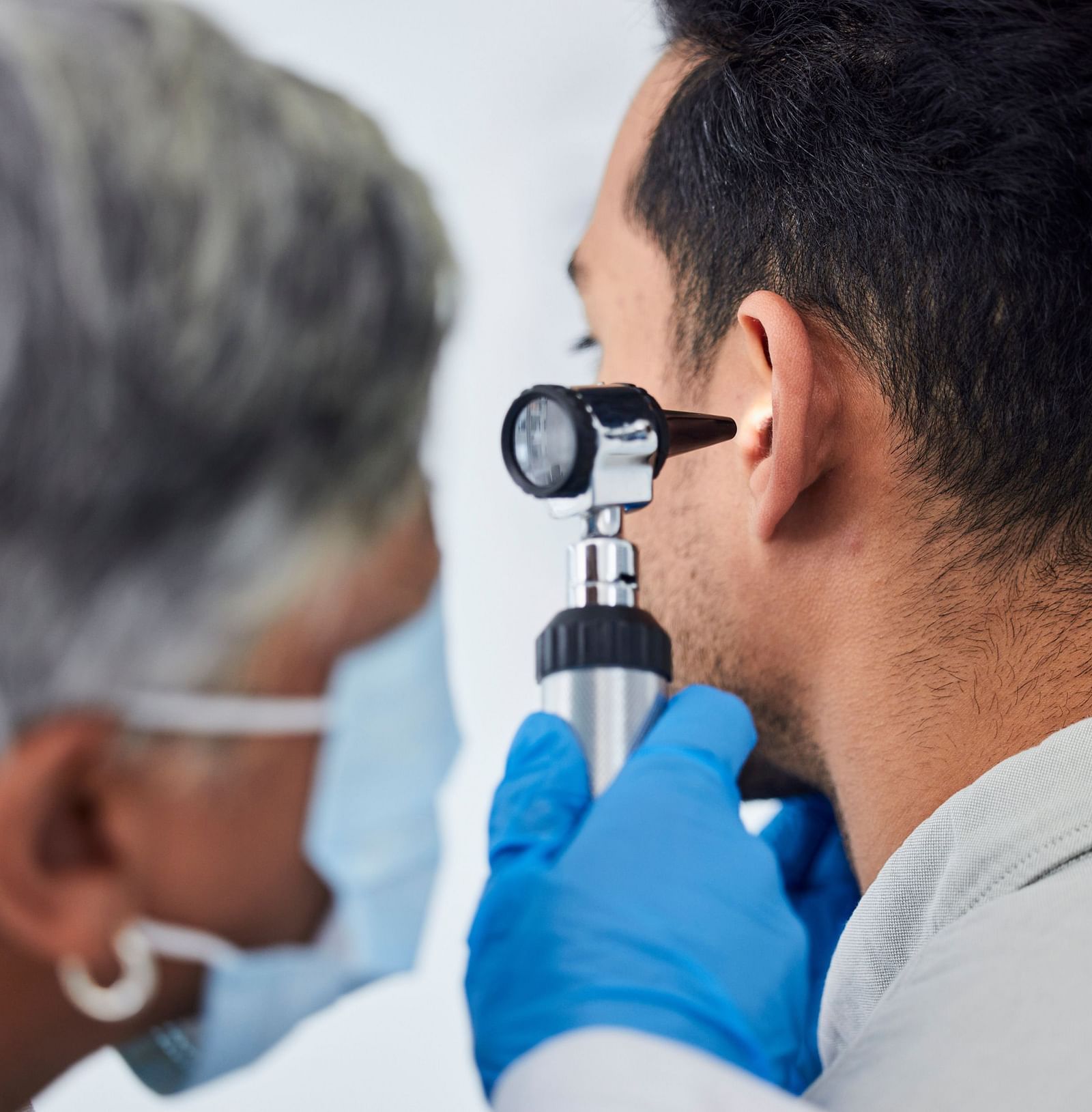 A doctor using an otoscope to examine a patient’s ear - Shreyas Retreat