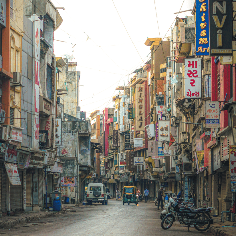 A market street of Gujarat with multiple shops and sign boards.