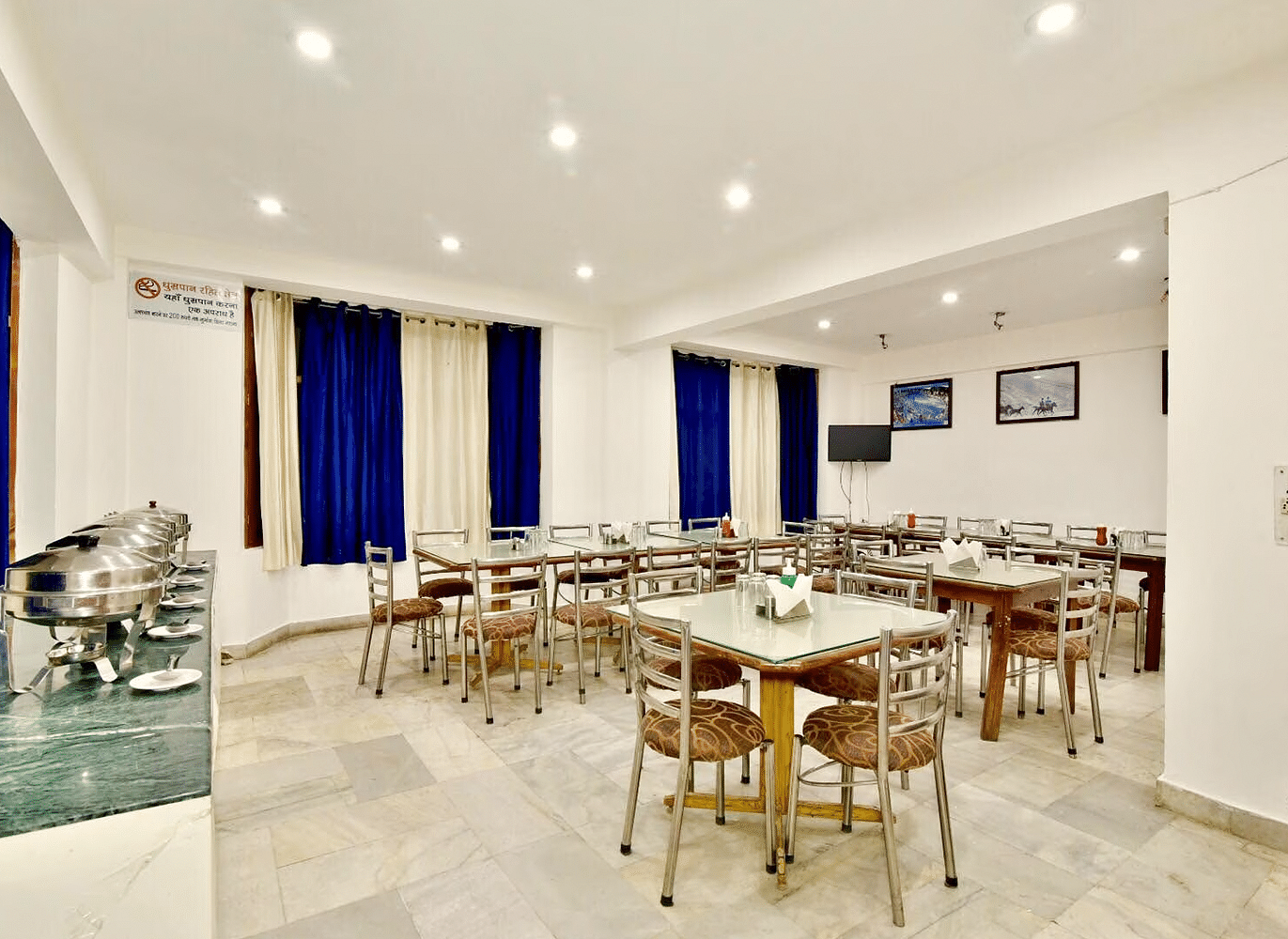 Well-lit interiors of the restaurant at DLS Hotel Devlok, Manali with the buffet arrangement towards the side