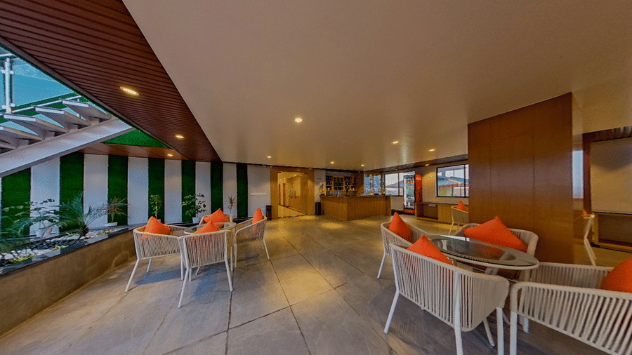 A side view of Distil bar featuring multiple chair with red cushions | Lords CBC Plaza, Chitwan