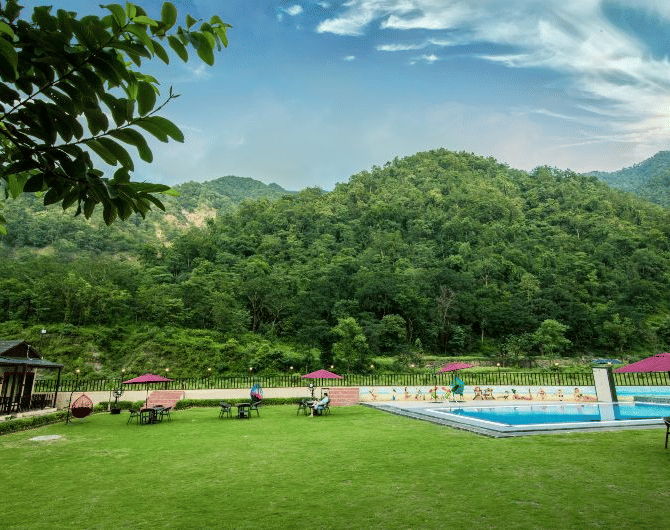 View of the swimming pool during the day at DLS MJ River Resort, Rishikesh.
