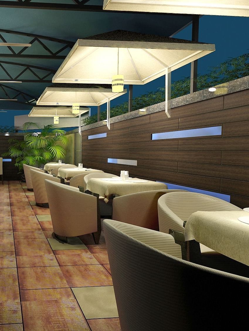 Outdoor dining area with chairs and tables arranged neatly, surrounded by plants at Oriental Aster, Mumbai.