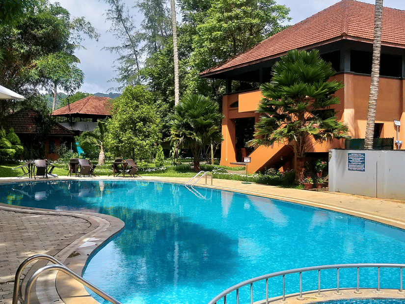 A view of an outdoor swimming pool near the cottages at Abad Abad Green Forest, Thekkady