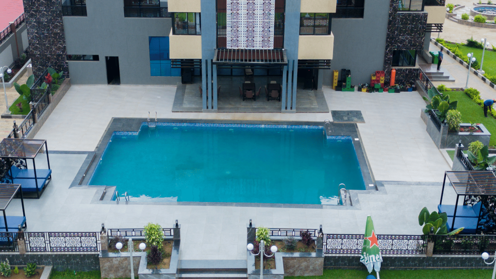 Aerial view of a modern building with a swimming pool and landscaped grounds - Luffu Club