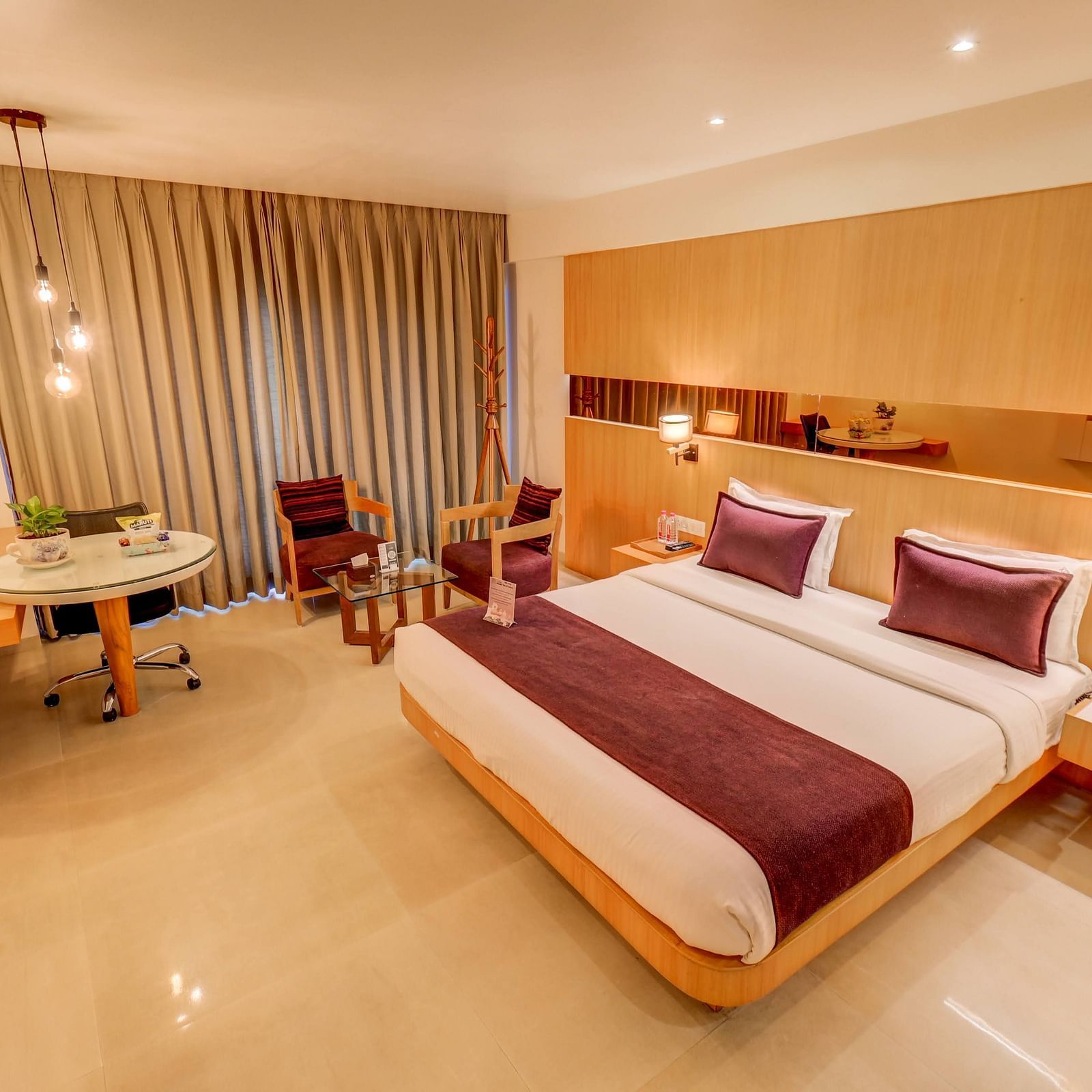 a view of the king sized bed and seating area at Deluxe room at SSK Solitaire Hotel And Banquets