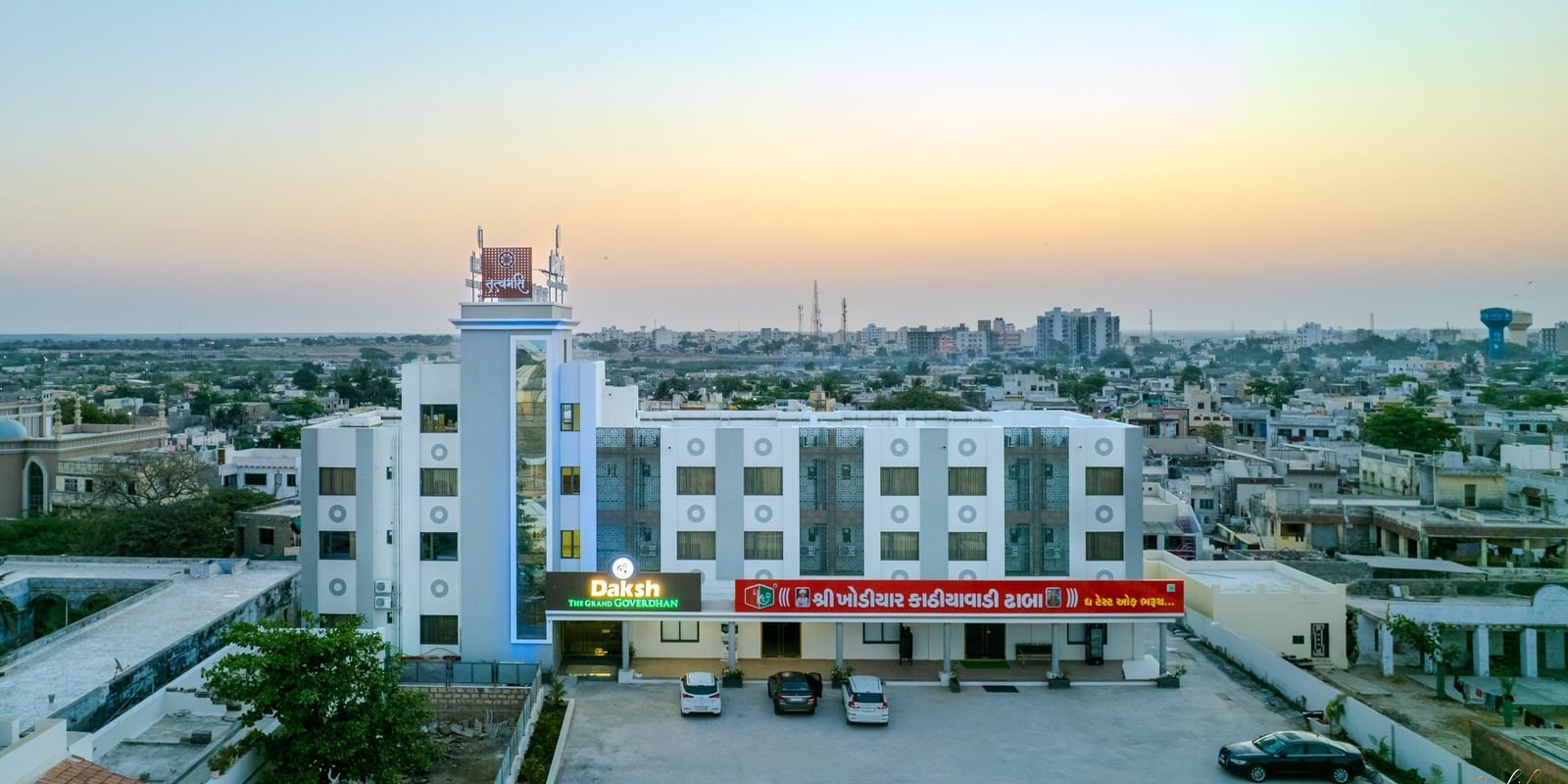 Expansive aerial view of Daksh The Grand Gowardhan, Dwarka, at dusk, revealing its impressive scale amidst the surrounding landscape.