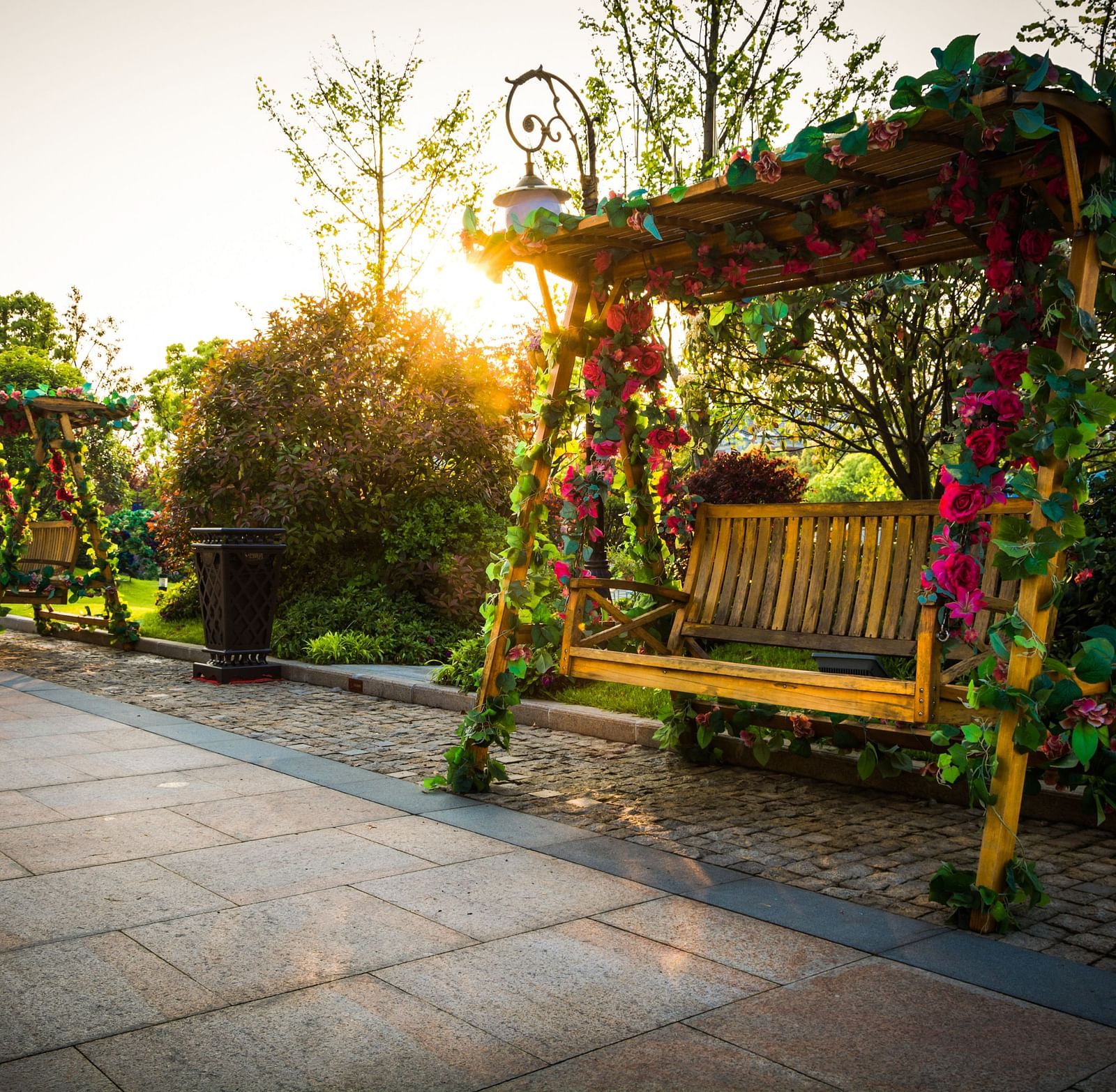 A wooden swing or bench in a garden setting and the sun casting a warm light and creating a lens flare effect. - Bamboo Saa Resort & Spa, Udaipur