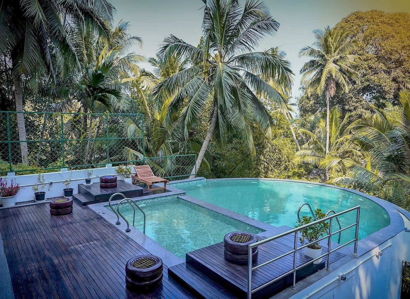 An outdoor swimming pool with clear blue water, surrounded by lush green tropical vegetation and trees - Sea Hills Hotels, Sri Vijayapuram (Port Blair)