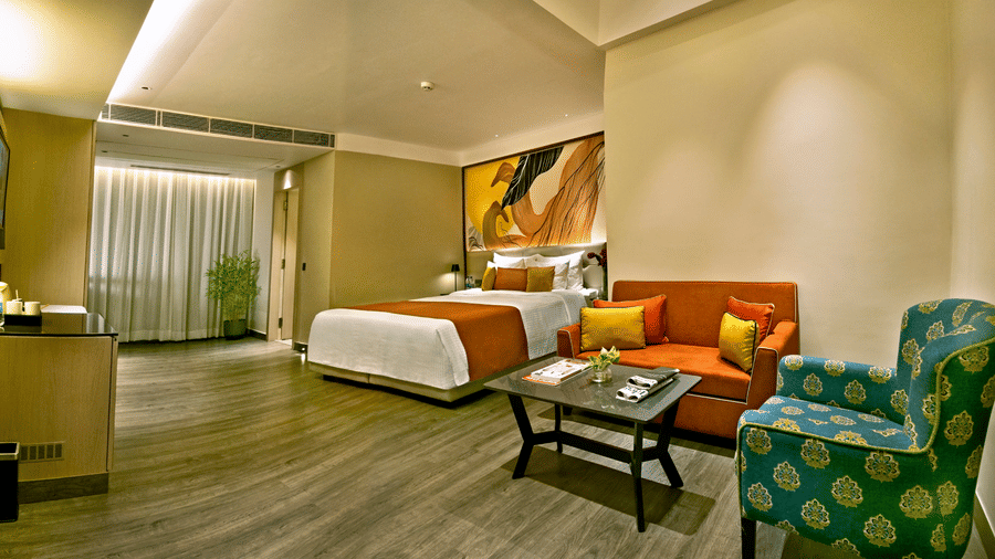Spacious suite with living area, green seating and modern design at The Sonnet, Jamshedpur.