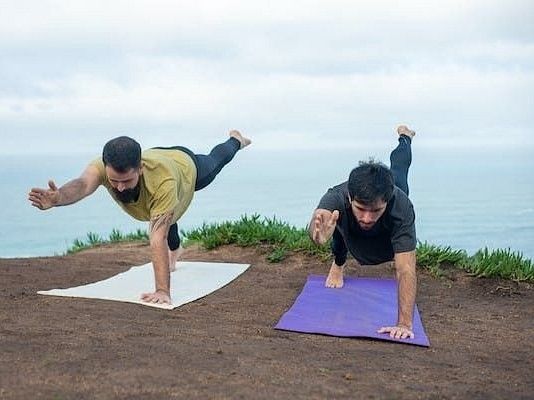 2 men doing yoga during daytime