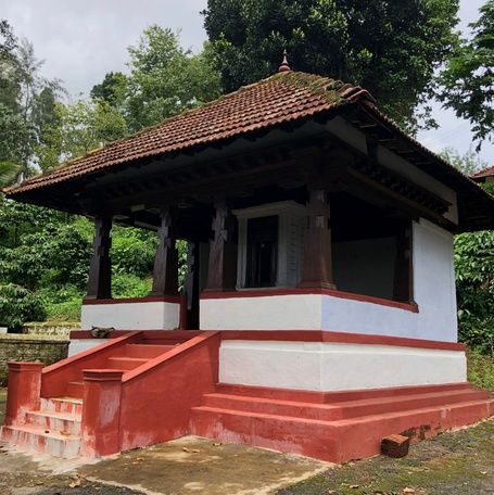 Kaimada shrine with red steps and tiled roof in Kodagu.