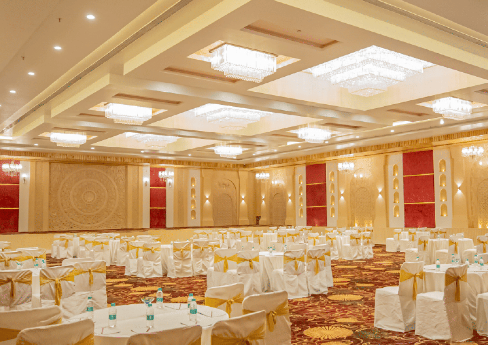 Image of a banquet hall with seating arrangement and fancy lights on the ceiling at Essentia Luxury Resort and Spa, Udaipur.