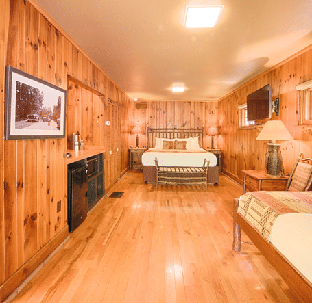 full view image of a bedroom with wooden interiors featuring two beds - Historic Tapoco Lodge