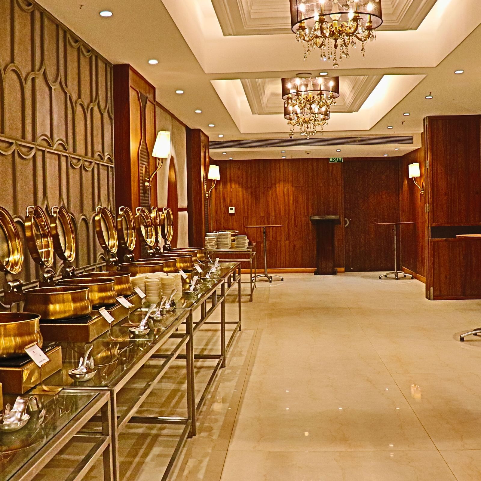 Buffet station with silver chafing dishes and ornate wall mirrors.
