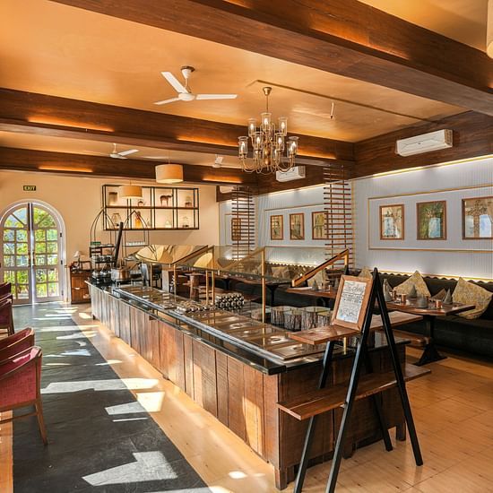A restaurant interior with a bar, tables, and warm lighting.