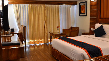 A premium room featuring balcony access, cosy lighting, and wooden flooring for a classy ambience - Benzz Park, Kodaikanal