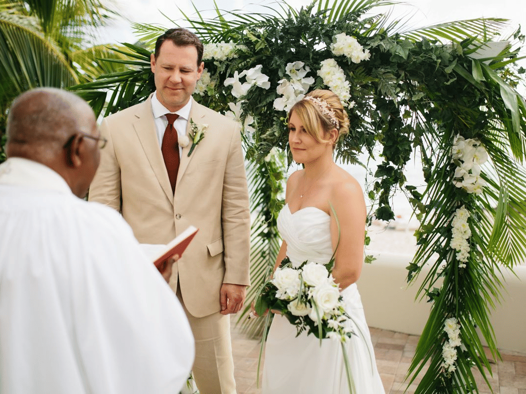 A couple getting married in the presence of the priest at The Soco Hotel, Barbados. 