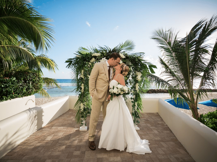 Recently married couple kissing on the wedding porch.