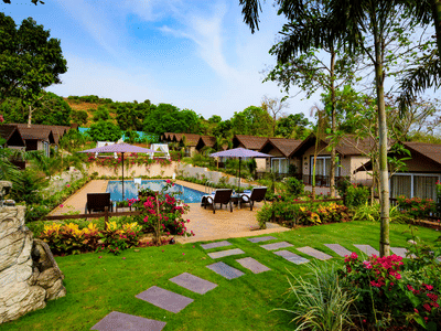 Garden with blooming flowers and cottages at Stone Wood Resorts in Mandrem