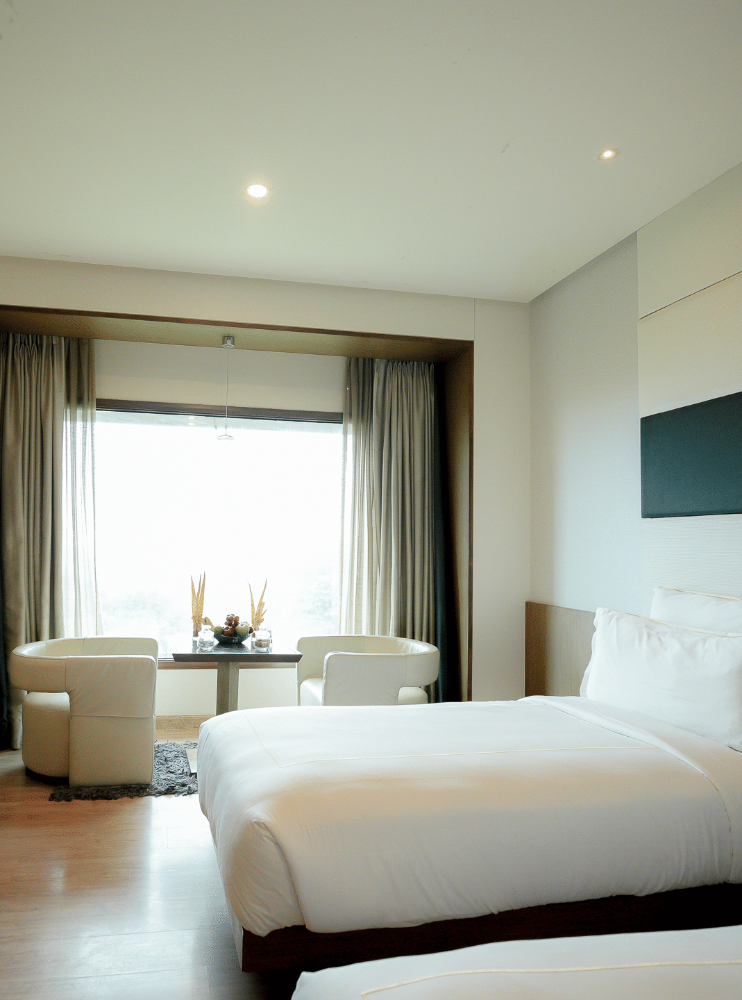 Spacious bedroom with minimalist furnishings and natural lighting – Narayani Heights Hotel & Resorts