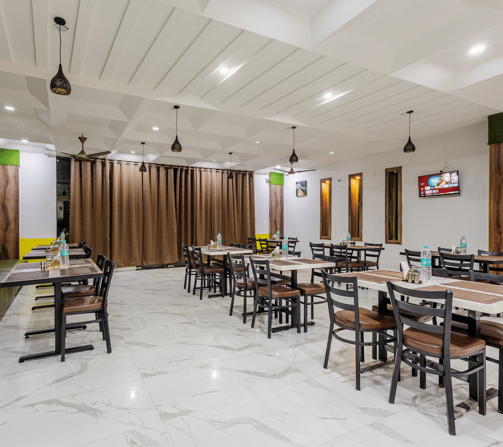The indoor restaurant at Lime Tree Hotels and Banquet, Vrindavan with well defined seating area.