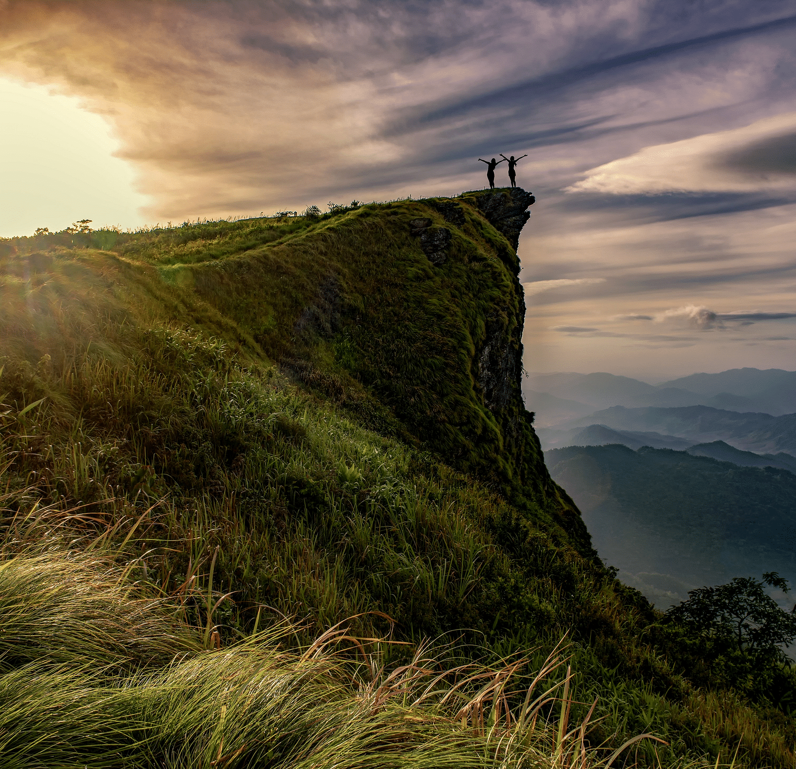Cliff overlooking a valley at sunrise.