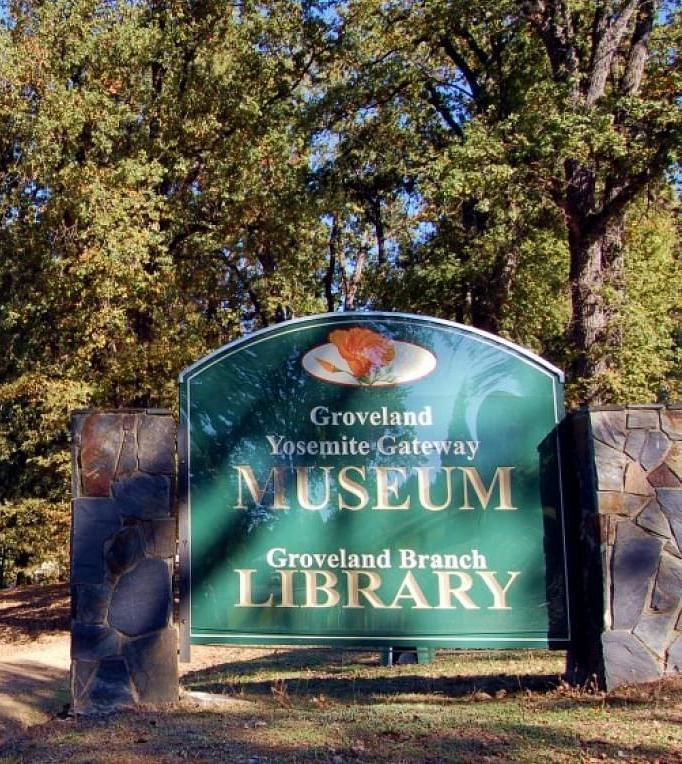 A sign reading Groveland Yosemite Gateway Museum and Groveland Branch Library - The Groveland Hotel.