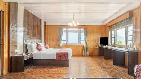Side view of a room with bed and wooden wall decor at Summit Tashi Ghang Heritage Resort, Pelling