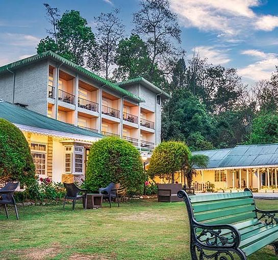 Lawn area of Summit Barsana Resort & Spa, Kalimpong with the hotel building in the backdrop
