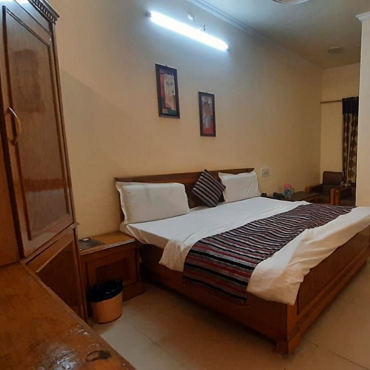 An image of a room in Roorkee with a king size bed, a cupboard and a television - Motel Divine International, Roorkee