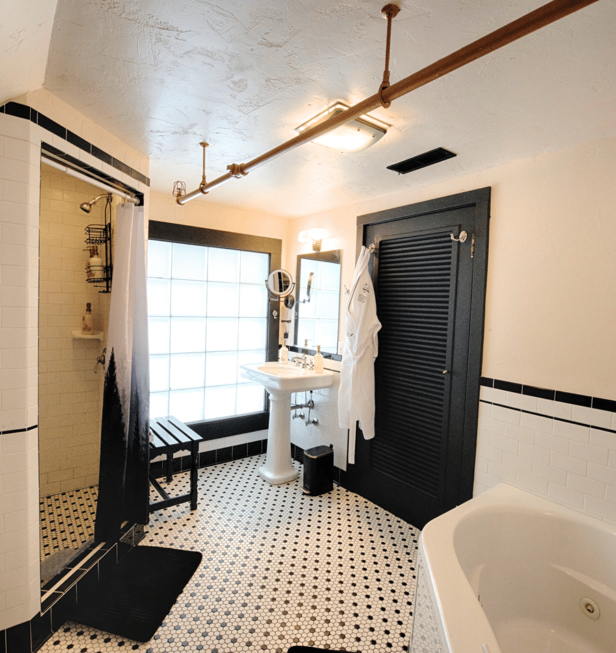 A bathroom with a shower, pedestal sink, and soaking tub