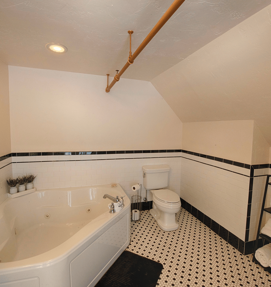 A clean and well-appointed bathroom with a large soaking tub, toilet, and tiled floor.