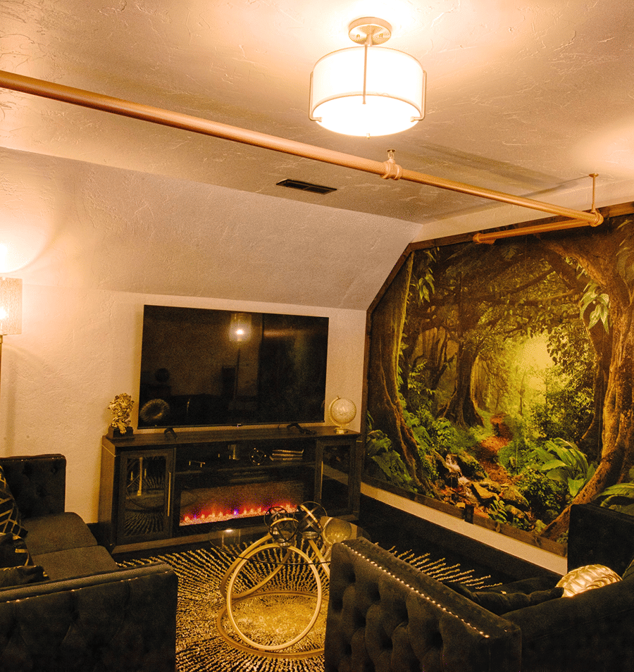 A cozy lounge area with a fireplace, TV, and seating for guests.