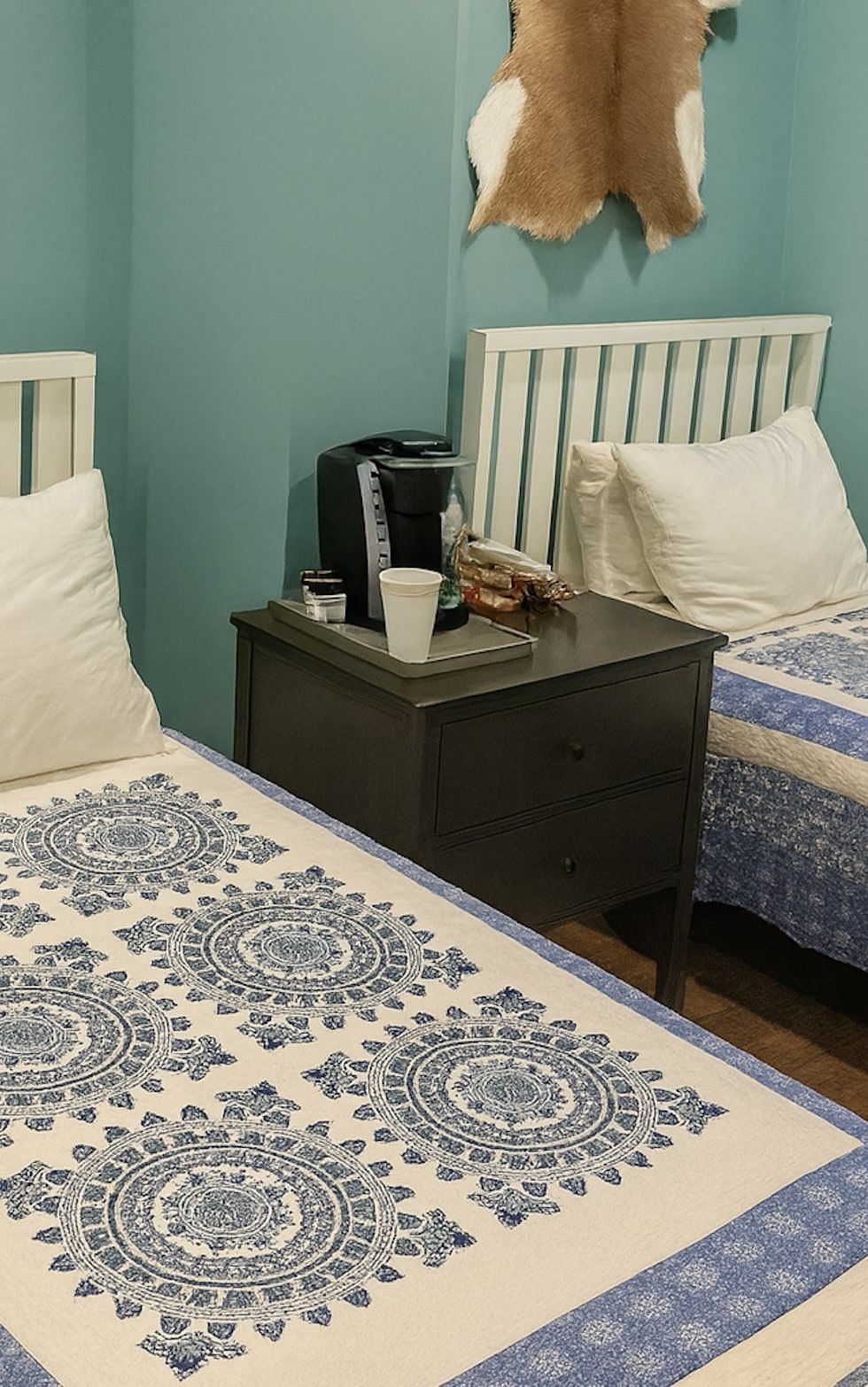 Deluxe Twin room at The Groverland Hotel, furnished with twin beds, a bedside table, and wooden flooring.