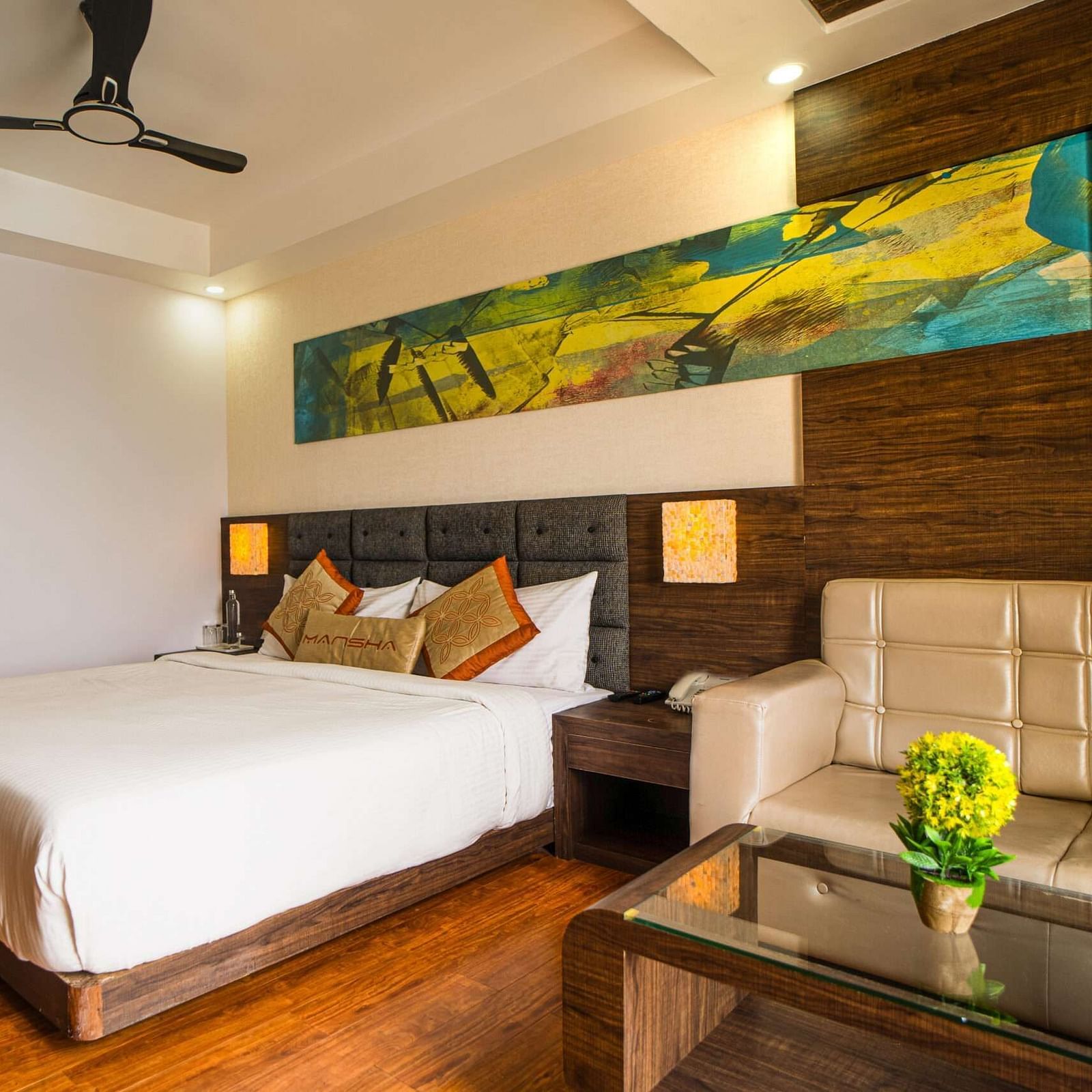 A room with a bed, a sofa, and a coffee table at Mansha Hotel Regency.
