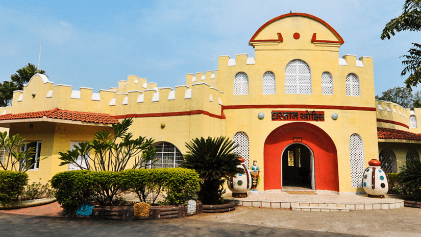 An exterior view of the Auto World Vintage Car Museum, featuring a welcoming person standing outside to greet visitors.
