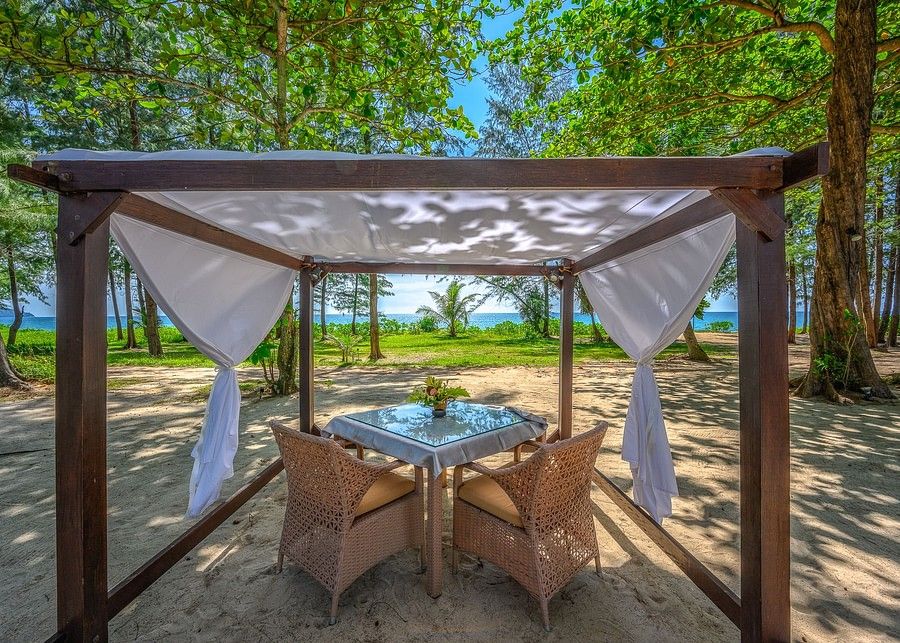 alt-text image of a dining table placed under a shed overlooking the beautiful sea and the tropical greenery - Maikhao Dream Villa Resort & Spa, Phuket