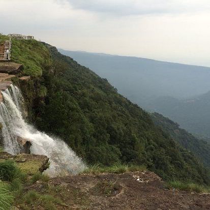 an aerial view of a waterfall amid hills