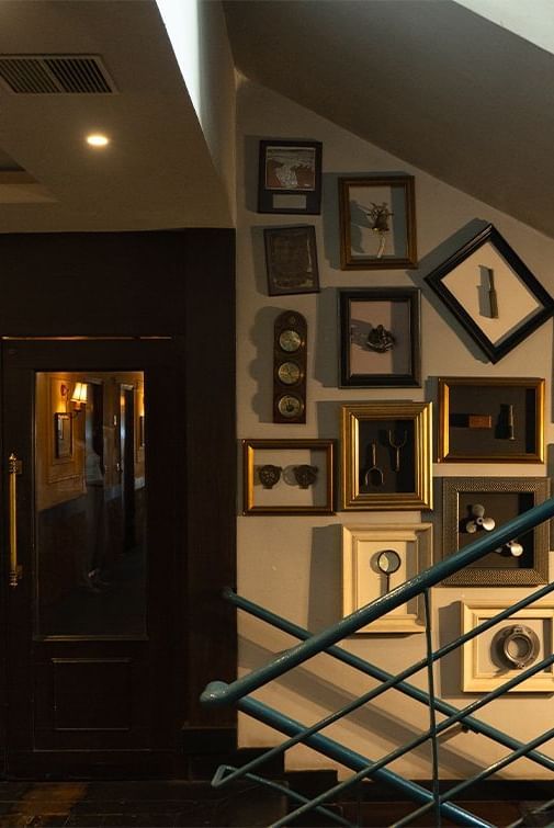 Interior staircase at Polo Floatel Kolkata with framed artwork on the walls and soft lighting.