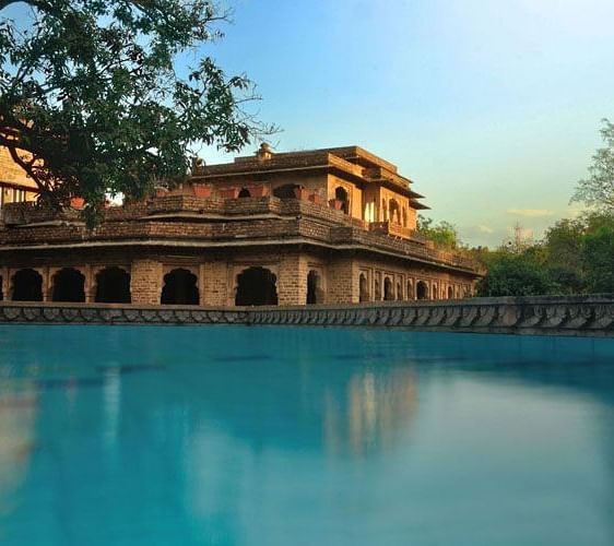 A facade image of Sukhdham Kothi seen from the side of a pool
