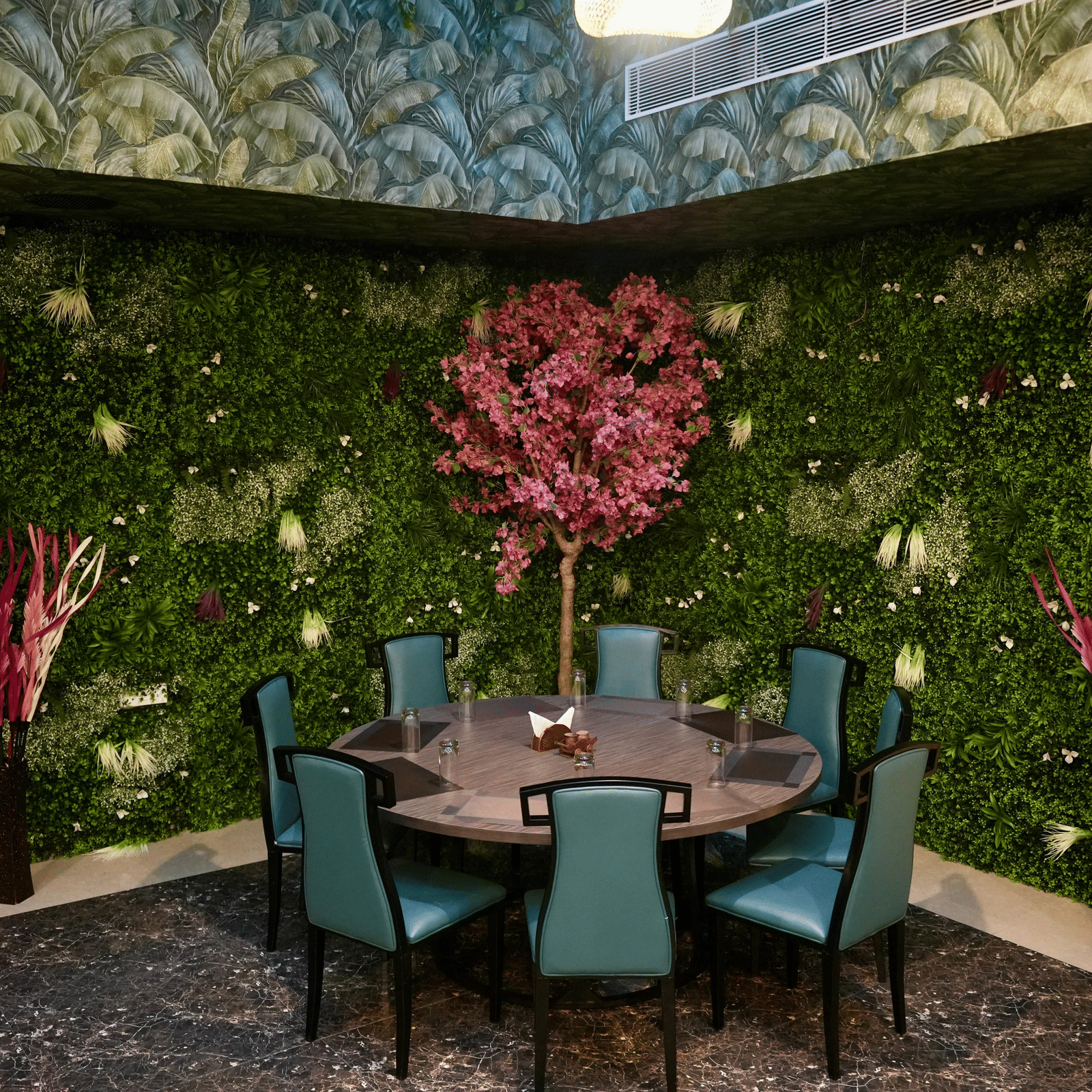 A well decorated dining area with a round table and multiple chairs at Le Royale Palace