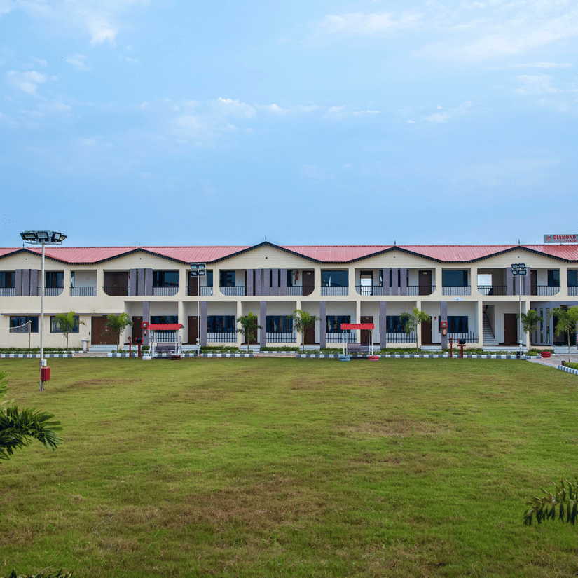 A wide shot of the resort building surrounded by a lush green lawn, showcasing the spacious and serene environment - VITS Select Diamond Resort, Sasan Gir