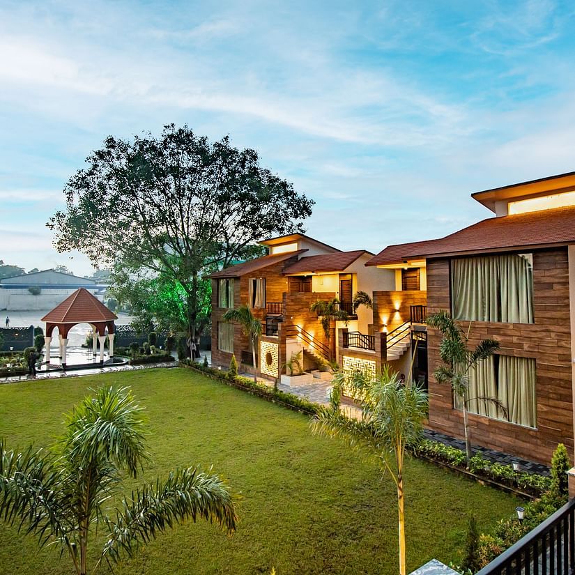 A scenic view of our hotel nestled near the lush lawn beneath the expansive open sky - Wedlock Greens Hotel & Resorts