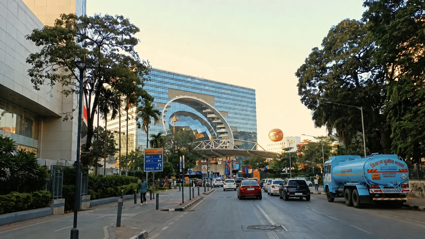 Street view of hotel entrance with archway structure and passing traffic