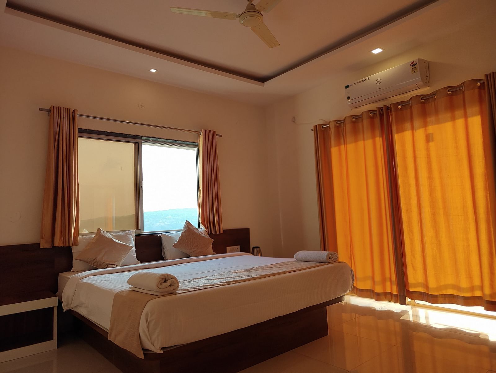 Superior Valley View Room with a large bed, orange curtains, and a window with a view.
